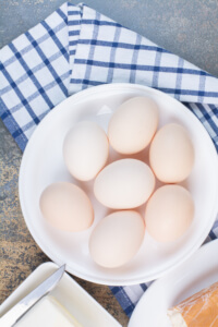 Boiled eggs on white plate with tablecloth