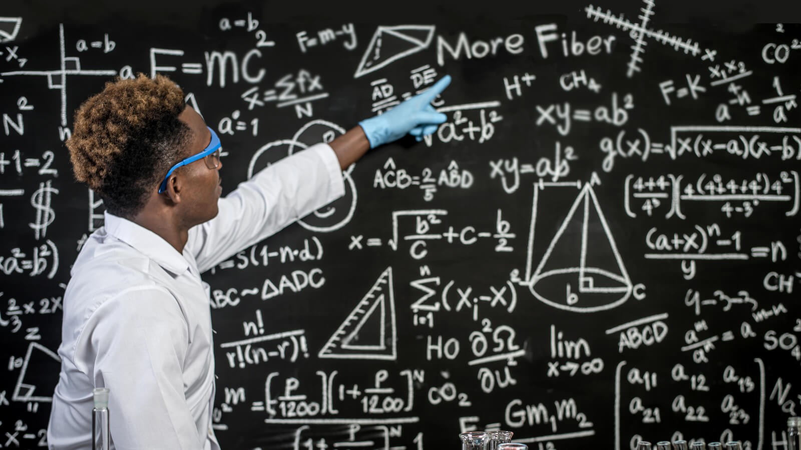 Scientists wear glasses and point to formulas on the blackboard